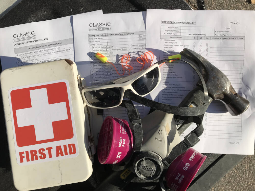 A Muskoka builder's construction safety inspection checklists, personal protective equipment and carpentry tools sit next to a first-aid kit.