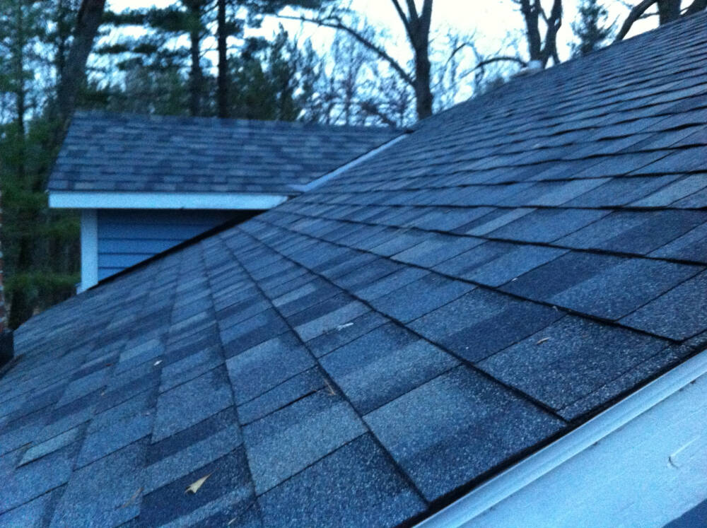 A shingle roof installation is pictured showing one of the highest priority building components subject this Muskoka custom builder's five year workmanship warranty.