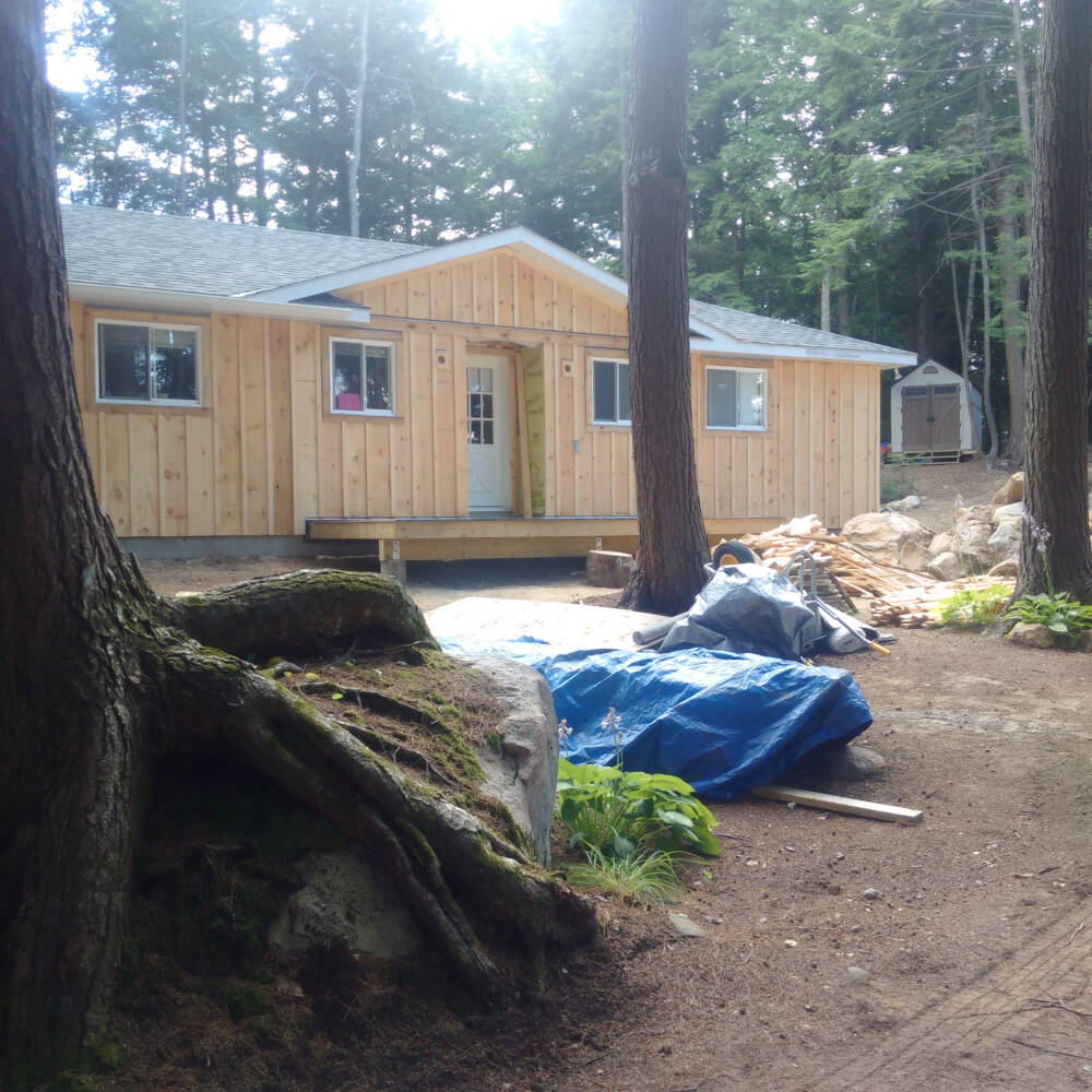 Exterior cladding or siding carpentry work is in progress on a Lake of Bays cottage building project in Muskoka, Ontario.