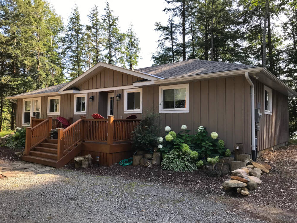 Painted vertical board and batten siding at a cottage exterior in the Township of Lake of Bays, Ontario.