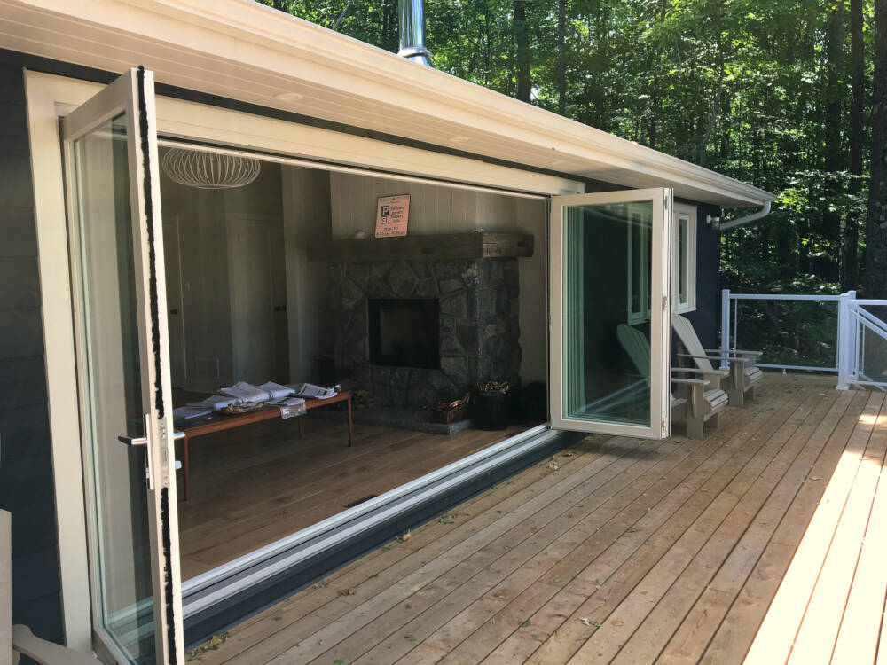 Home design with large, wide bifolding glass doors opening from the Living Room to the sun deck overlooking Lake Muskoka.