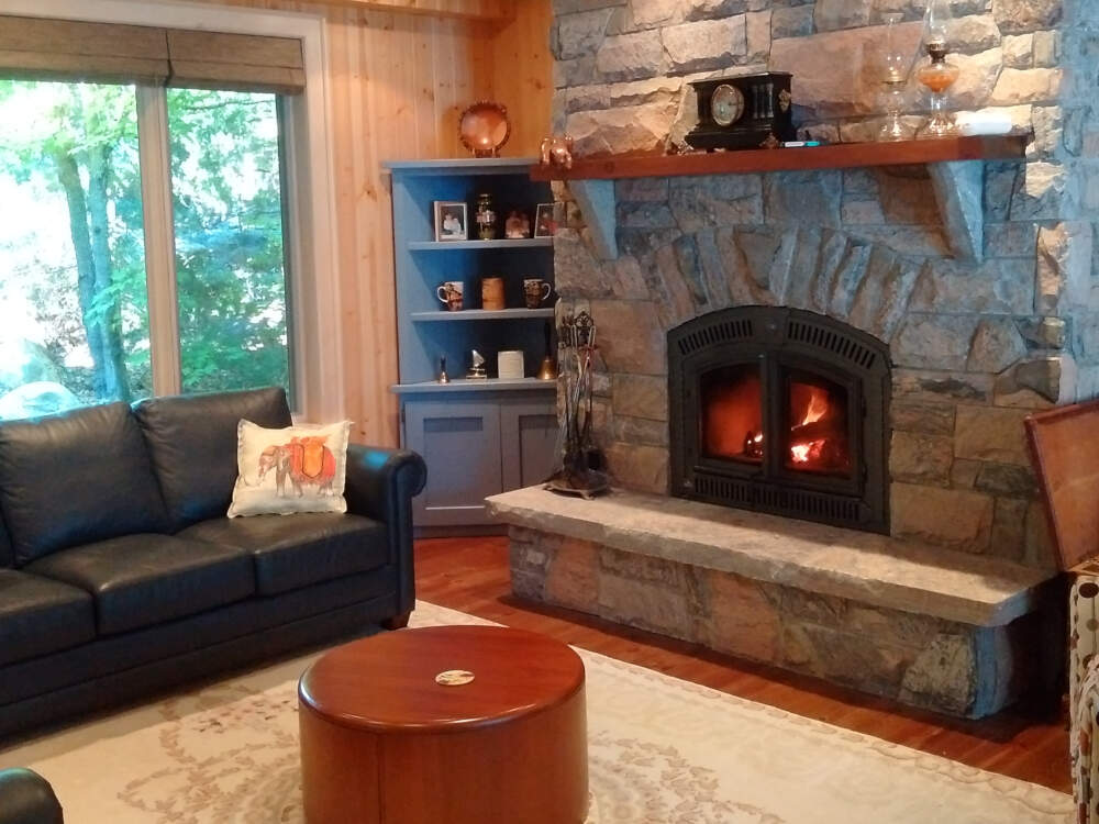A wood-burning fireplace built of stone masonry construction is a traditional and central feature in homes and cottages in Muskoka, Ontario.