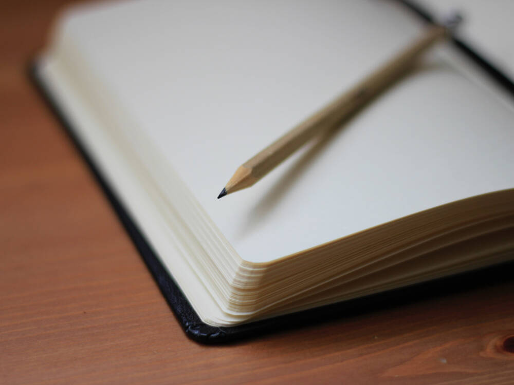 Pencil and notebook represent the idea of taking notes from our money-saving tips for building in Muskoka.