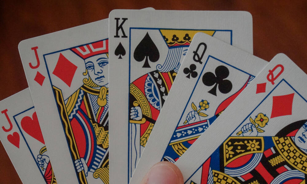Playing cards in the hand of a poker game player represent the gamble, risk or uncertainty inherent in construction contracts and costs.