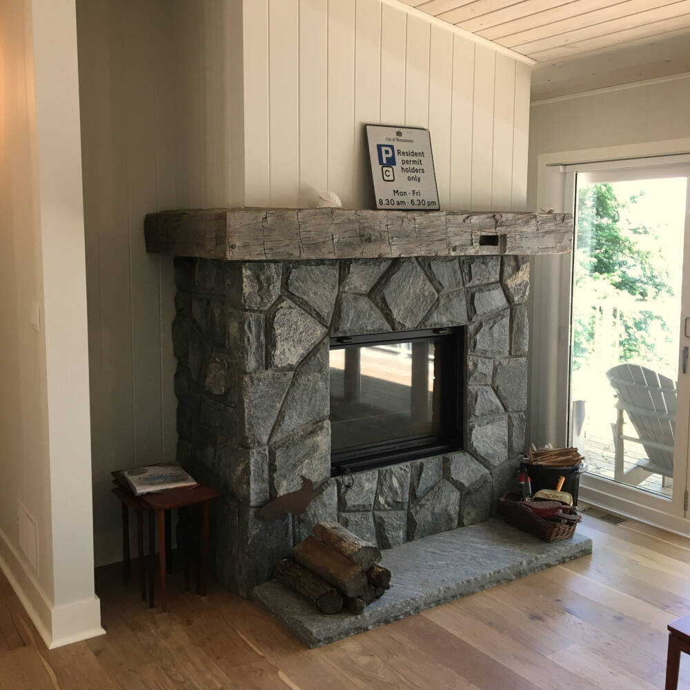 Entry door decorated with a gable covered entry roof and finial designed by Classic Muskoka Homes.