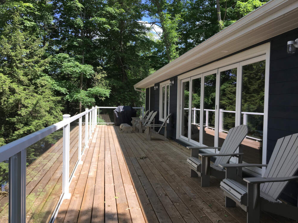 A waterfront deck bathed in sunlight is a featured design element of this home plan on Lake Muskoka.