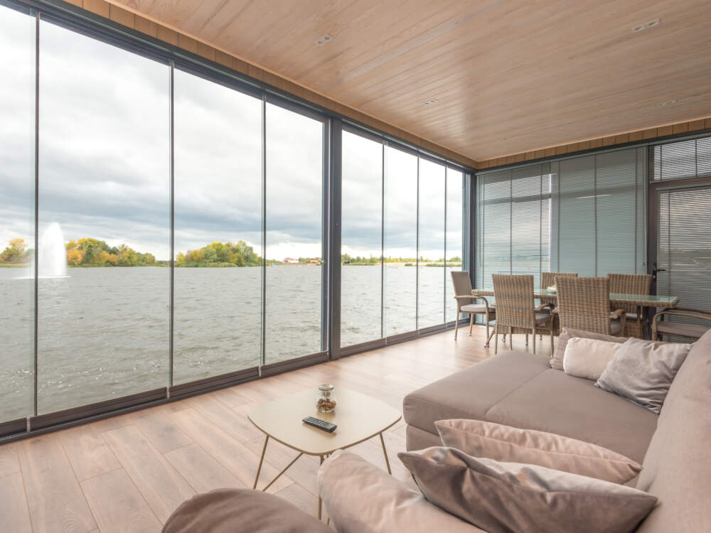 Lift and slide doors with full glass area offer access to outdoors, excellent ventilation and wide landscape views in modern home and cottage designs.