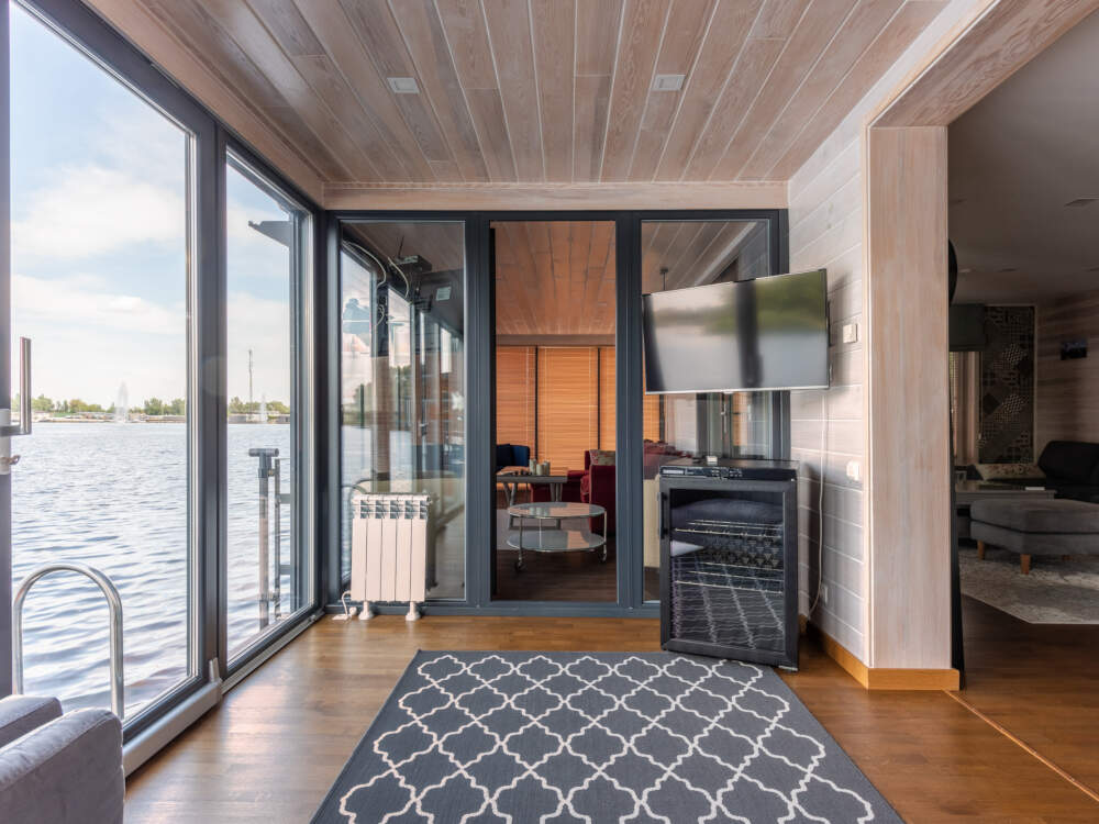 Modern home design offering large picture window glass opening onto the waterfront for expansive panoramic landscape views.