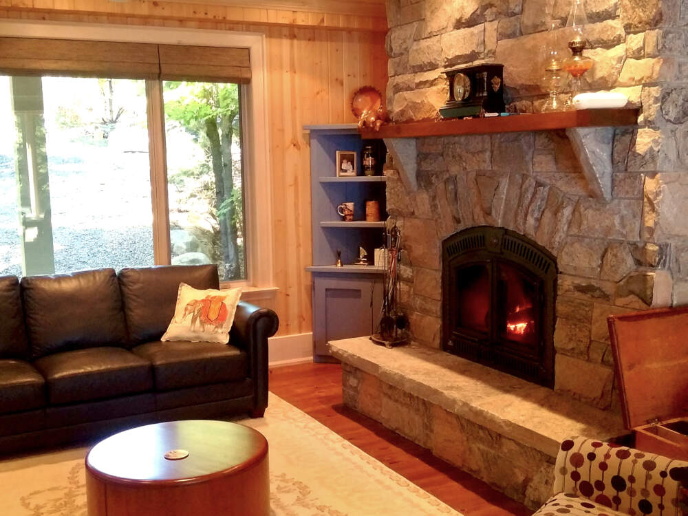 A classic stone fireplace is the centrepiece of the Living Room in this traditional Muskoka cottage design.
