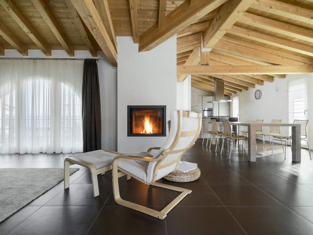 Bright white painted walls contrast against heavy timber roof and ceiling framing in this timber frame house design.