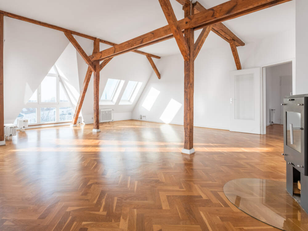 Solid timber beams, posts and knee braces are featured at the interior of a timber frame residence design.