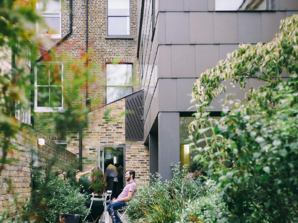 Modern sheet metal cladding contrasts against traditional brick-clad exterior walls in a transitional architectural design.
