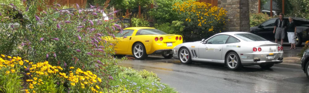 A bright yellow Corvette sports car and a silver Ferrari sports care are pictured behind a feature landscape garden at the J.W. Marriott resort hotel in Minett, Muskoka, Ontario.