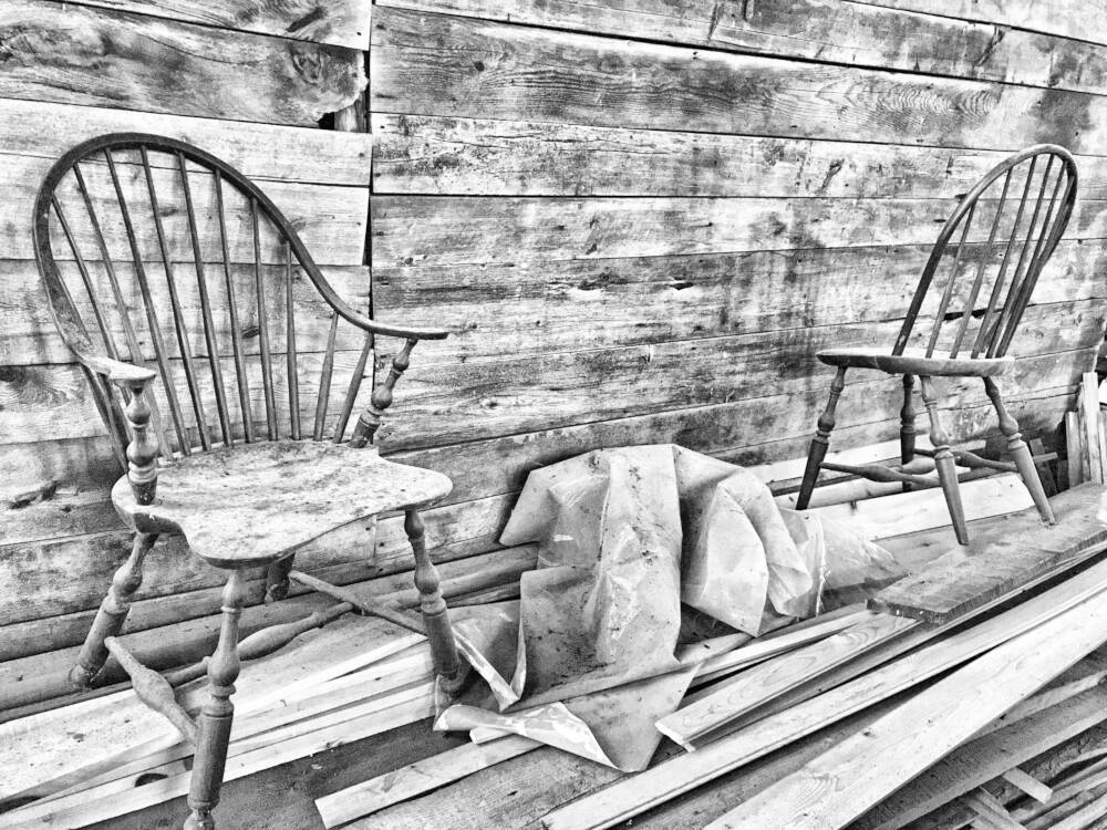 Traditional Shaker style Windsor chairs are pictured in grayscale against a rustic barnboard backdrop.